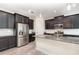 Modern kitchen with stainless steel appliances, dark wood cabinets, granite countertops, and a spacious island at 5871 Alenlon Way, Mount Dora, FL 32757