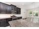 Stylish kitchen features granite countertops, stainless steel appliances, and dark cabinets with subway tile backsplash at 5871 Alenlon Way, Mount Dora, FL 32757