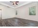 Bright main bedroom featuring tray ceiling, fan, and wood-look flooring at 5871 Alenlon Way, Mount Dora, FL 32757