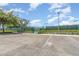 Community tennis courts with lights surrounded by a privacy fence and green landscaping at 5871 Alenlon Way, Mount Dora, FL 32757