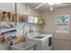Bright laundry room featuring a washer, dryer, utility sink and storage shelves at 611 Green Briar Blvd, Altamonte Springs, FL 32714