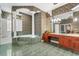 A well lit primary bathroom with a soaking tub, custom columns, and vanity with decorative light fixture at 612 Stonefield Loop, Lake Mary, FL 32746
