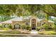 Stately home featuring a tiled roof, arched windows, mature landscaping, and a welcoming entrance at 612 Stonefield Loop, Lake Mary, FL 32746