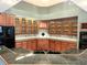 A kitchen featuring wood cabinets with glass doors, complemented by black appliances at 612 Stonefield Loop, Lake Mary, FL 32746