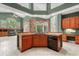 A kitchen island featuring a sink, wood cabinets, and a dishwasher, leading to an open living area at 612 Stonefield Loop, Lake Mary, FL 32746