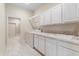 A well-lit laundry room with white cabinets, a sink, and a washer/dryer at 612 Stonefield Loop, Lake Mary, FL 32746