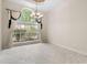 Bright living room with large windows, chandelier, tile flooring, and stylish curtains at 612 Stonefield Loop, Lake Mary, FL 32746
