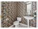 Quaint powder room featuring a pedestal sink with decorative wallpaper at 612 Stonefield Loop, Lake Mary, FL 32746