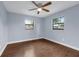 A simple bedroom offers natural light from two windows and a ceiling fan at 6431 Greylynne St, Orlando, FL 32807