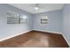 Bedroom with large windows, ceiling fan, hardwood floors and neutral paint at 6431 Greylynne St, Orlando, FL 32807