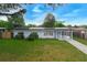 Charming single-story home with well-maintained lawn, carport, and solar panels under a bright blue sky at 6431 Greylynne St, Orlando, FL 32807