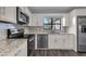 Well lit kitchen with granite countertops, stainless steel appliances and white cabinets at 6431 Greylynne St, Orlando, FL 32807