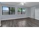Spacious living room with large windows, new wood flooring and neutral paint at 6431 Greylynne St, Orlando, FL 32807