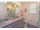 Well-lit bathroom with double vanity, granite countertop, and decorative mirror at 6960 Audobon Osprey Cv, Harmony, FL 34773
