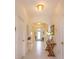 Bright and open hallway with neutral walls, tiled flooring, and elegant decor accents at 6960 Audobon Osprey Cv, Harmony, FL 34773