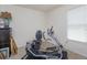 Bright exercise room with stationary bike, neutral walls and carpet, and window for natural light at 6960 Audobon Osprey Cv, Harmony, FL 34773