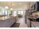 Bright kitchen with granite counters and gray cabinetry with a view into the dining and living areas at 6960 Audobon Osprey Cv, Harmony, FL 34773