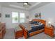 Tranquil main bedroom featuring a tray ceiling, plush bedding, and serene water views at 6960 Audobon Osprey Cv, Harmony, FL 34773