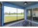 Enclosed patio with table and chairs overlooking backyard and serene water feature views at 6960 Audobon Osprey Cv, Harmony, FL 34773