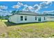 This shot shows a large backyard with the house featuring neutral paint, windows, and a sliding glass door at 701 Marion Oaks Trl, Ocala, FL 34473