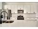 Modern kitchen features stainless steel appliances, sleek white cabinetry, and quartz countertops at 701 Marion Oaks Trl, Ocala, FL 34473