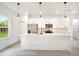 Bright kitchen featuring a quartz island with pendant lighting, stainless appliances, and white cabinets at 701 Marion Oaks Trl, Ocala, FL 34473