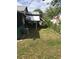 A side view of house featuring a screened in back porch and a grassy side yard at 710 W Swoope W Ave, Winter Park, FL 32789