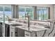 Close-up view of a granite countertop wet bar with a beer tap, under-cabinet lighting, and white cabinetry at 711 Windlass Ct, Kissimmee, FL 34746
