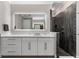 The bathroom offers an illuminated mirror over a vanity, and a walk-in shower with dark tile at 711 Windlass Ct, Kissimmee, FL 34746