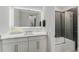 Well-lit bathroom with a large mirror, elegant vanity, candles, and a tub-shower with glass doors at 711 Windlass Ct, Kissimmee, FL 34746