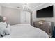 Relaxing bedroom features a comfortable bed, sleek mirrored dresser, modern lighting, and a wall-mounted television at 711 Windlass Ct, Kissimmee, FL 34746