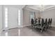 Elegant dining room adjacent to the foyer featuring a modern chandelier and floor to ceiling windows at 711 Windlass Ct, Kissimmee, FL 34746