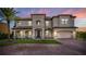 Stately two-story home with lush landscaping, a brick driveway, and a grand entrance at dusk at 711 Windlass Ct, Kissimmee, FL 34746