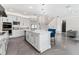 Modern kitchen with white cabinets, stainless appliances, island, and adjacent staircase at 711 Windlass Ct, Kissimmee, FL 34746