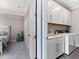 Functional laundry room featuring cabinetry, sink, washer, dryer, with bedroom view at 711 Windlass Ct, Kissimmee, FL 34746
