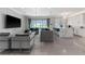 Open-concept living room with pool views, modern furniture, and a sleek entertainment setup at 711 Windlass Ct, Kissimmee, FL 34746
