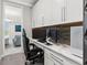 Office nook with a white desk, built-in cabinets, and a sleek black desk chair at 711 Windlass Ct, Kissimmee, FL 34746