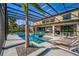 A stunning screened-in pool area with a spa, lounge chairs, and lush landscaping creates a private oasis at 711 Windlass Ct, Kissimmee, FL 34746
