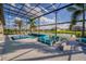 A stunning screened-in pool area with a spa, fire pit, comfortable seating, and beautiful water views at 711 Windlass Ct, Kissimmee, FL 34746
