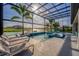 Beautiful screened-in pool area with a spa, lounge chairs, and lush landscaping offers a private escape at 711 Windlass Ct, Kissimmee, FL 34746