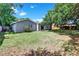 Expansive backyard with a well-maintained lawn, mature trees, and a charming exterior view of the home at 7709 Pine Hollow Ct, Orlando, FL 32822