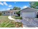 Charming single-story home with a well-maintained lawn, paved walkway, and attached two-car garage at 7709 Pine Hollow Ct, Orlando, FL 32822