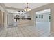 Bright open kitchen with white cabinetry, black countertops, and an adjacent dining area at 7709 Pine Hollow Ct, Orlando, FL 32822