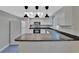Well-lit kitchen with white cabinets, sleek black countertops, and stainless steel appliances at 7709 Pine Hollow Ct, Orlando, FL 32822