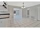 Open kitchen with white cabinets, black countertops, and seamless flow to the dining area at 7709 Pine Hollow Ct, Orlando, FL 32822