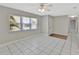 Bright, tiled living room featuring a ceiling fan, large window, and neutral paint at 7709 Pine Hollow Ct, Orlando, FL 32822