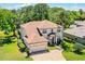 Aerial view of a two-story home with a brick driveway and lush landscaping in a wooded area at 772 Pickfair Ter, Lake Mary, FL 32746