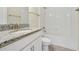 The bathroom features granite countertop, white cabinets, tub and tiled shower at 7809 Purple Finch St, Winter Garden, FL 34787