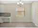 Cozy dining area featuring a large window, chandelier, and built-in desk with granite countertops at 7809 Purple Finch St, Winter Garden, FL 34787