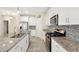 Stylish kitchen with stainless steel appliances, granite countertops, an island, and modern tile backsplash at 7809 Purple Finch St, Winter Garden, FL 34787